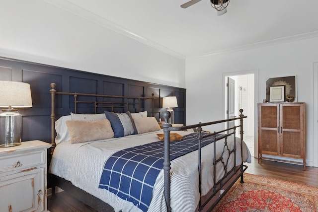 bedroom featuring a decorative wall, crown molding, and wood finished floors