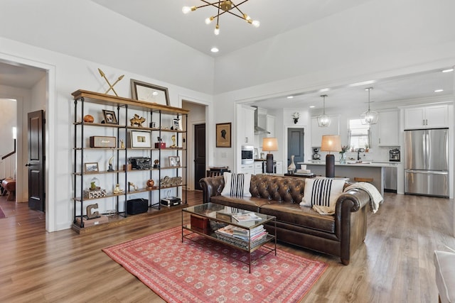 living area featuring light wood-style flooring, a chandelier, and recessed lighting