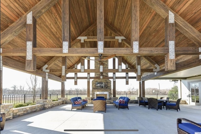 view of patio / terrace featuring a gazebo, an outdoor living space with a fireplace, and fence