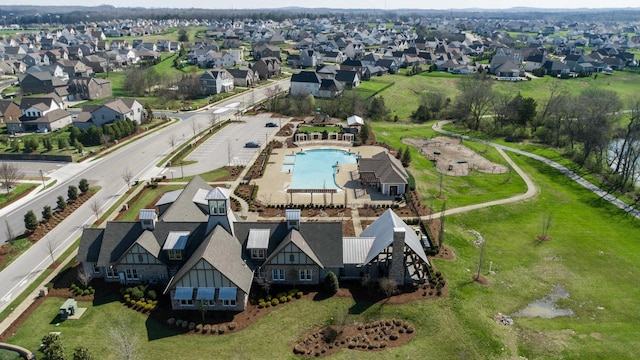 aerial view of property's location featuring a pool area and nearby suburban area