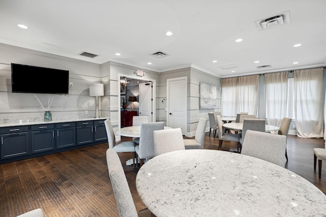 dining room with crown molding, dark wood-style floors, and recessed lighting