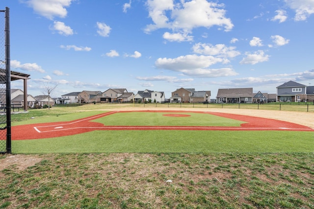 view of basketball court with a residential view and fence