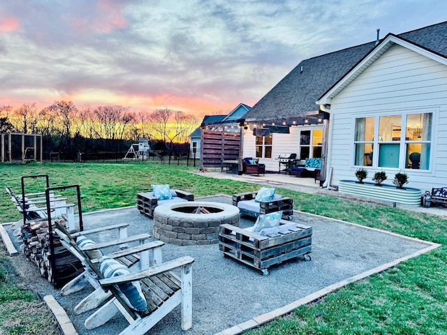 patio terrace at dusk with an outdoor living space with a fire pit
