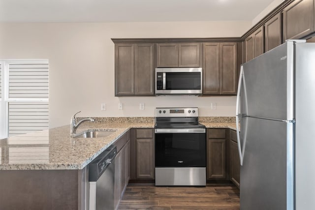 6078 Cullen Dr, La Vergne, TN 37086 - kitchen featuring light stone counters, a peninsula, dark wood-style flooring, a sink, and appliances with stainless steel finishes