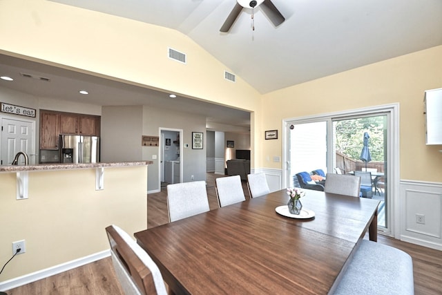 dining space with visible vents, dark wood finished floors, and vaulted ceiling