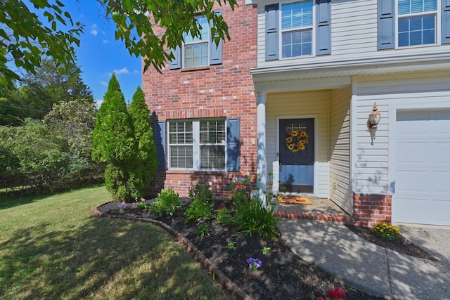 entrance to property with brick siding, a garage, and a lawn