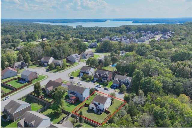 aerial view with a residential view, a view of trees, and a water view