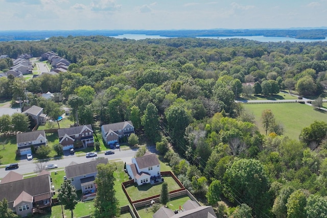 drone / aerial view with a residential view, a wooded view, and a water view