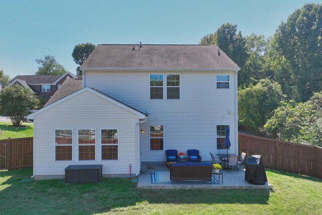 back of house with a fenced backyard, a lawn, a patio, and roof with shingles