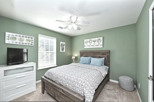 bedroom with a ceiling fan, visible vents, light colored carpet, and baseboards