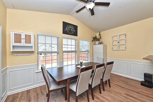 dining area featuring wainscoting, ceiling fan, lofted ceiling, and wood finished floors