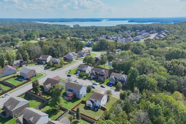 drone / aerial view featuring a water view, a forest view, and a residential view