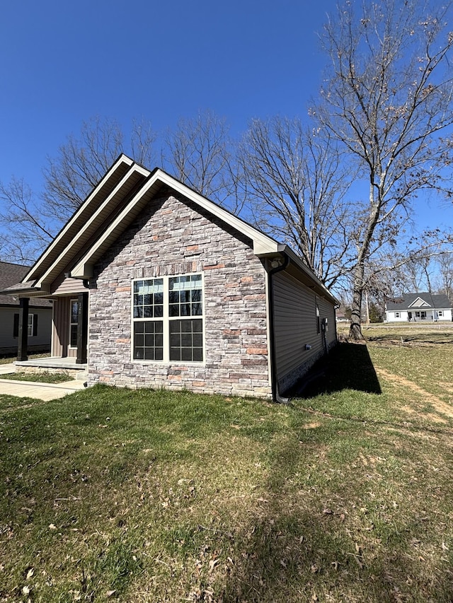 view of property exterior featuring stone siding and a lawn