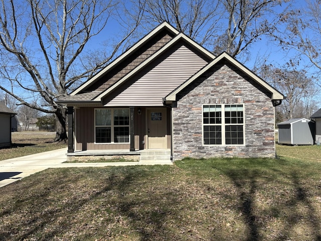 view of front of property featuring a storage unit, a front lawn, stone siding, board and batten siding, and an outdoor structure