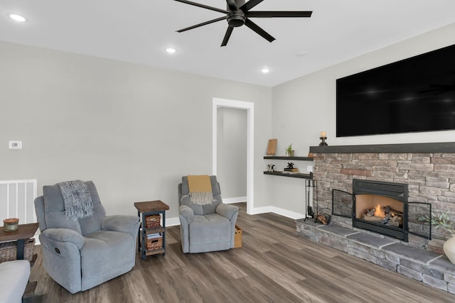 living room featuring visible vents, baseboards, recessed lighting, a fireplace, and wood finished floors