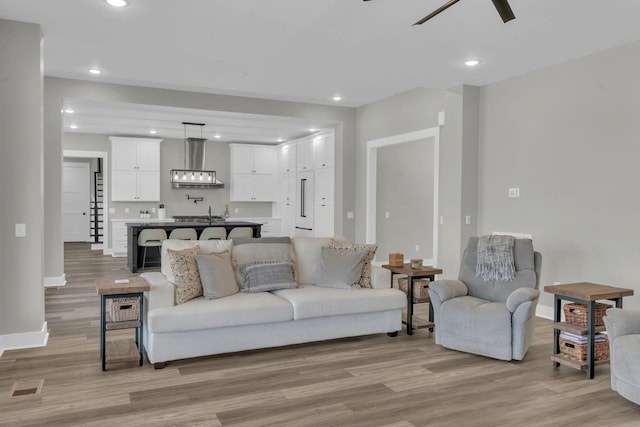 living area with recessed lighting, visible vents, and light wood finished floors