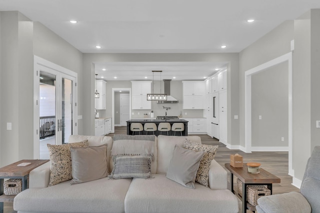 living room featuring dark wood-type flooring, recessed lighting, and baseboards