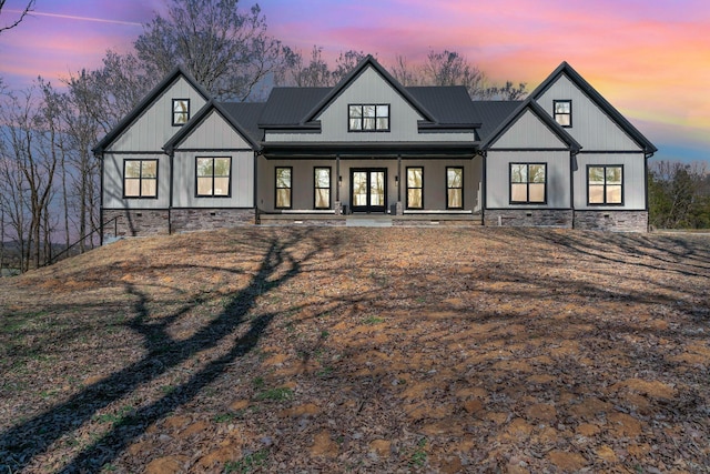 view of front of home with board and batten siding, covered porch, and metal roof