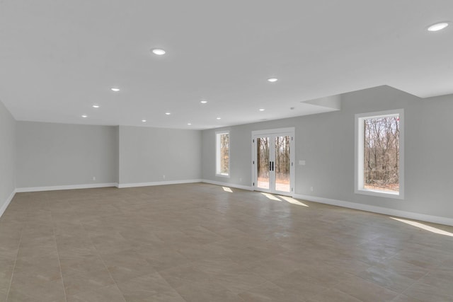 unfurnished living room with recessed lighting and baseboards