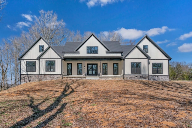 modern farmhouse style home featuring covered porch, board and batten siding, metal roof, and a standing seam roof