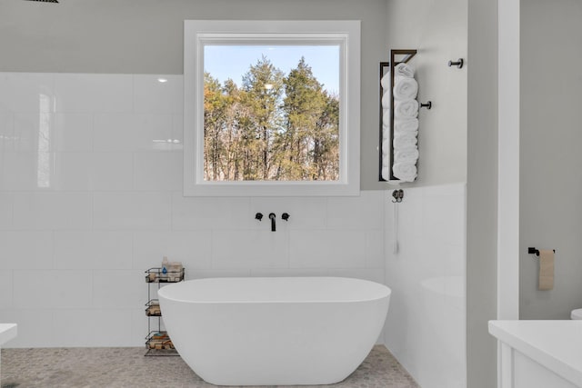 full bathroom featuring a soaking tub and tile walls