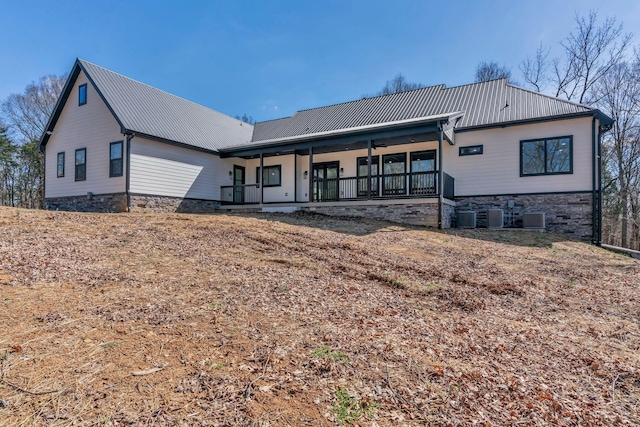 back of house featuring metal roof, a porch, and central AC