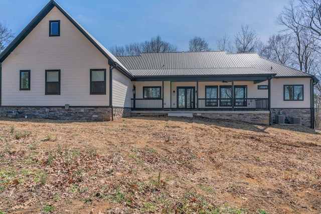 rear view of house with metal roof, covered porch, and a standing seam roof