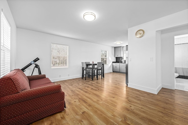 living area featuring light wood-type flooring and baseboards