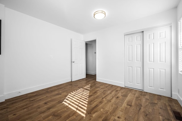 unfurnished bedroom with visible vents, baseboards, and dark wood-style flooring