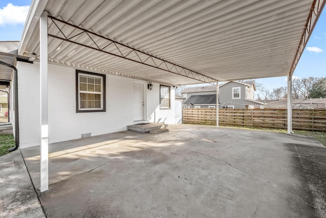 view of patio featuring an attached carport and fence