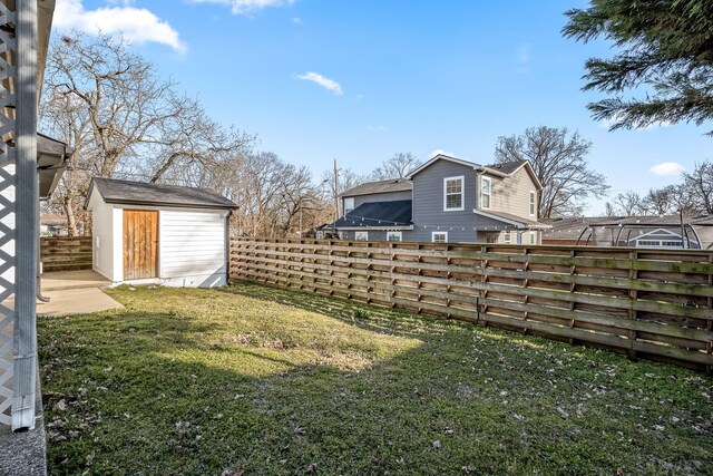 view of yard with a shed, an outdoor structure, and fence