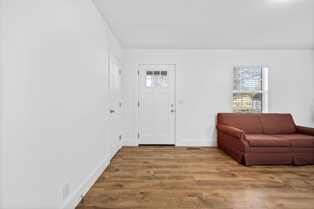 foyer entrance featuring baseboards and wood finished floors