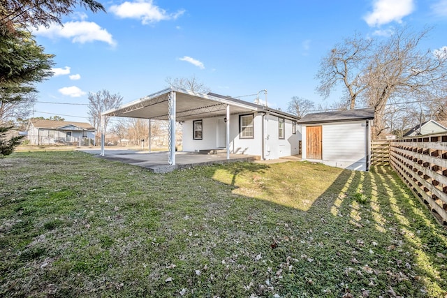 view of front facade featuring a patio, a front yard, fence, an outdoor structure, and a storage shed