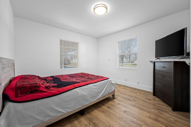 bedroom featuring baseboards and wood finished floors