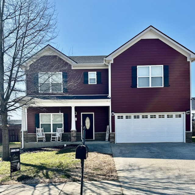 traditional-style home with a garage, stone siding, a porch, and driveway