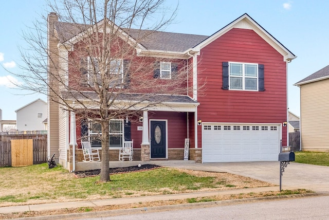 traditional-style house featuring driveway, fence, covered porch, an attached garage, and a front yard