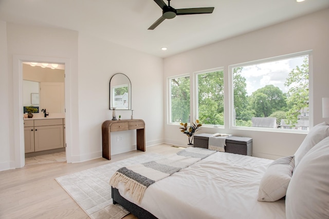 bedroom featuring recessed lighting, connected bathroom, baseboards, and a sink