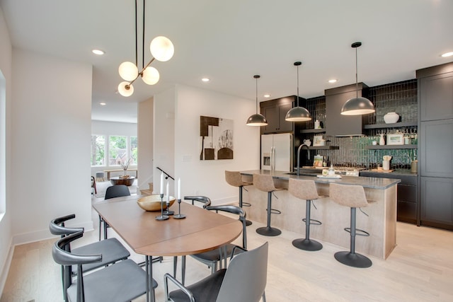 dining space with recessed lighting, light wood-type flooring, and baseboards