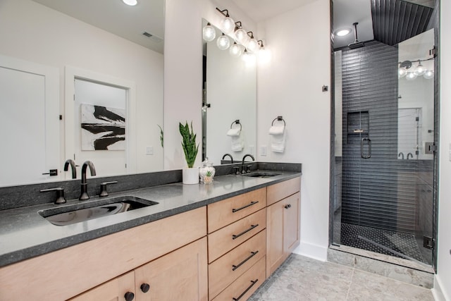 full bath with double vanity, visible vents, a stall shower, and a sink