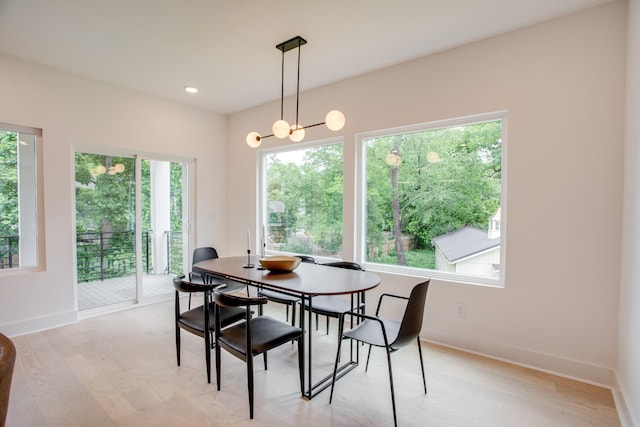 dining space with light wood-style flooring, a notable chandelier, recessed lighting, and baseboards