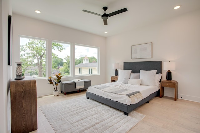 bedroom with recessed lighting, multiple windows, baseboards, and light wood-style floors