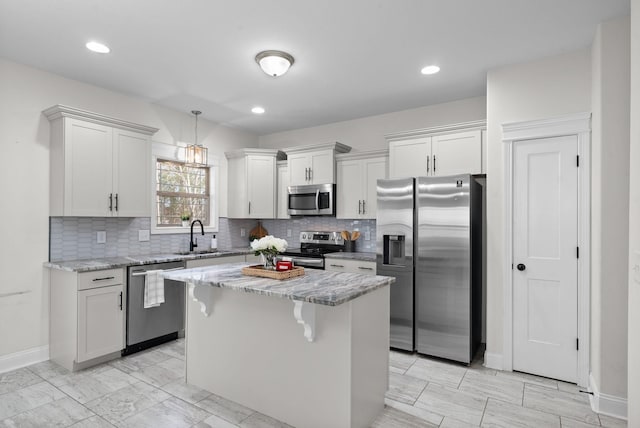 kitchen with a sink, light stone counters, a center island, and stainless steel appliances