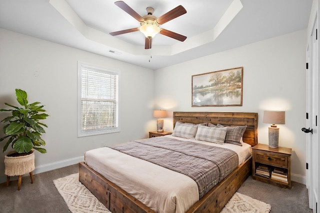 bedroom with visible vents, carpet, a raised ceiling, and baseboards