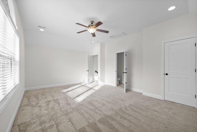 unfurnished bedroom featuring visible vents, lofted ceiling, carpet flooring, baseboards, and ceiling fan