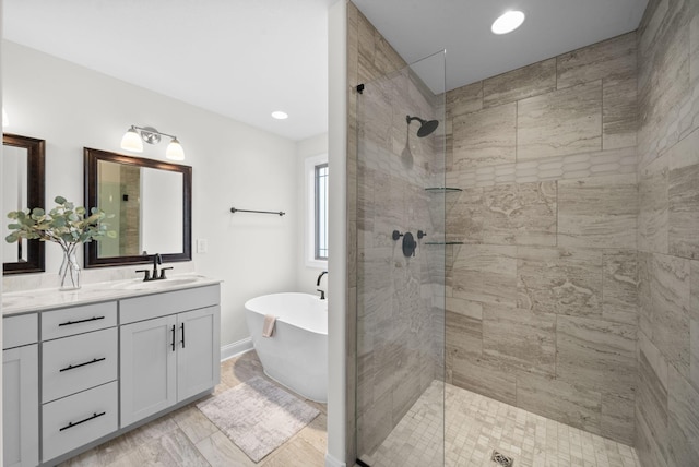 full bathroom with double vanity, recessed lighting, a freestanding bath, a sink, and walk in shower