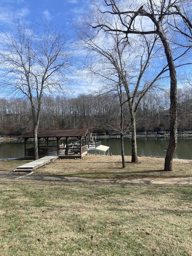 view of yard featuring a wooded view and a water view