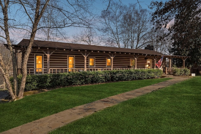 log home featuring log siding, a lawn, a porch, and a chimney