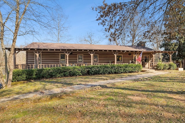 back of property with a shingled roof, a yard, covered porch, and a chimney