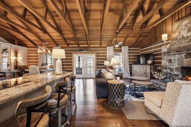 living room featuring wood walls, lofted ceiling with beams, and dark wood-type flooring