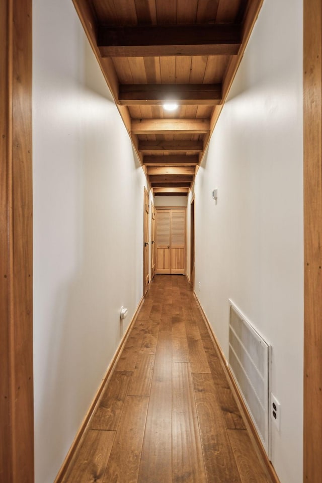 hallway with visible vents, beamed ceiling, wood ceiling, and hardwood / wood-style flooring
